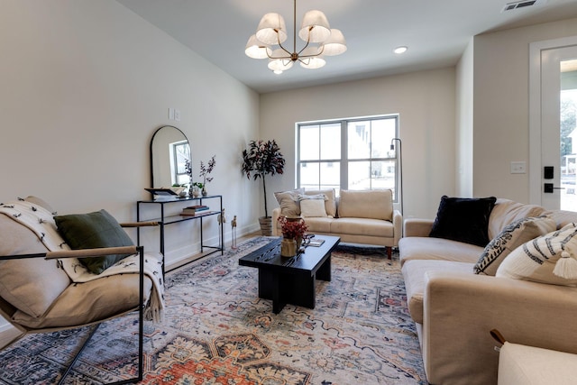 living room with baseboards, plenty of natural light, visible vents, and an inviting chandelier