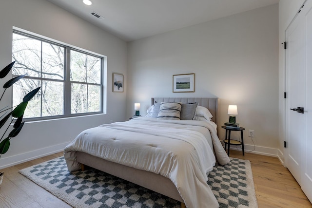 bedroom featuring light wood-type flooring, visible vents, baseboards, and recessed lighting