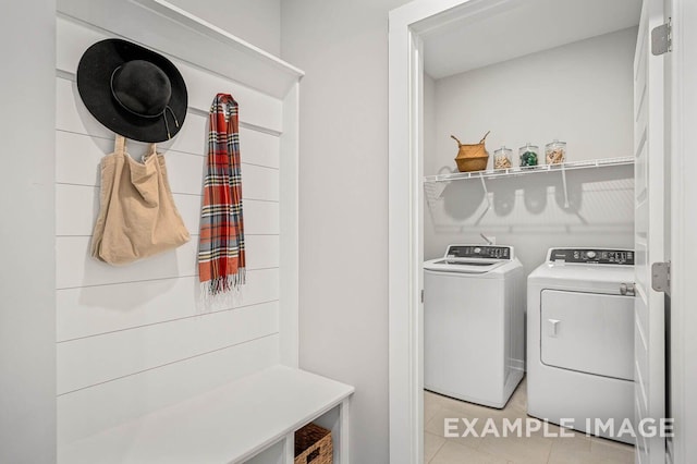 clothes washing area with laundry area, washer and clothes dryer, and light tile patterned floors