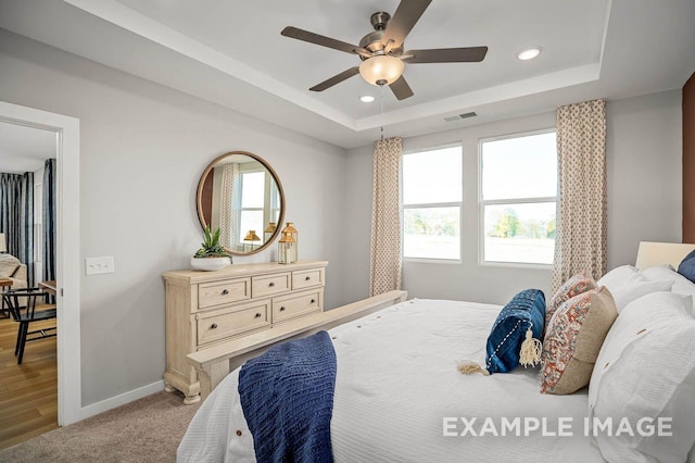 bedroom with recessed lighting, a raised ceiling, visible vents, and baseboards