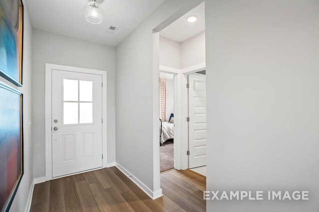 doorway with baseboards, visible vents, and dark wood-style flooring