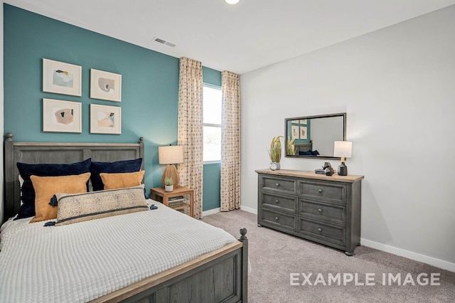 bedroom with light carpet, visible vents, and baseboards