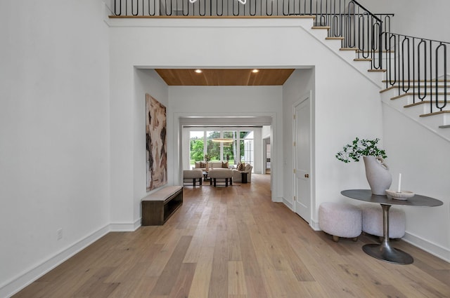 entrance foyer featuring wooden ceiling, baseboards, stairway, and hardwood / wood-style floors