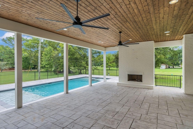 view of swimming pool featuring ceiling fan, a lawn, a patio area, and a fenced backyard