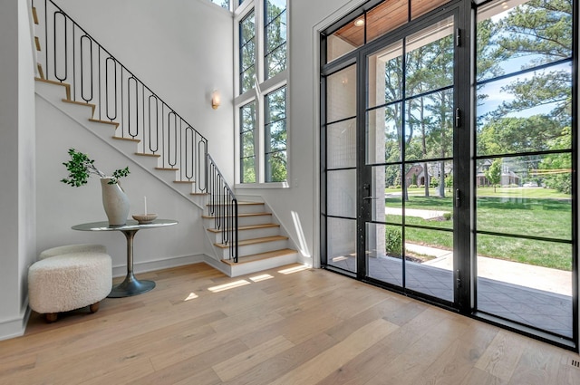 entryway featuring stairs, wood finished floors, and baseboards