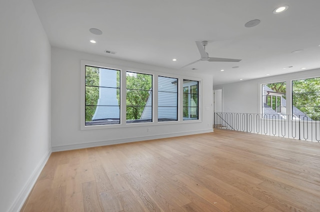 unfurnished room with baseboards, visible vents, a ceiling fan, light wood-style floors, and recessed lighting