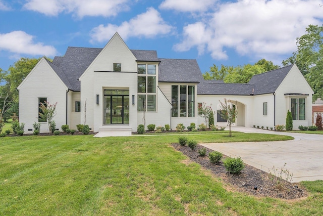 view of front of home with a shingled roof, a front yard, concrete driveway, and crawl space