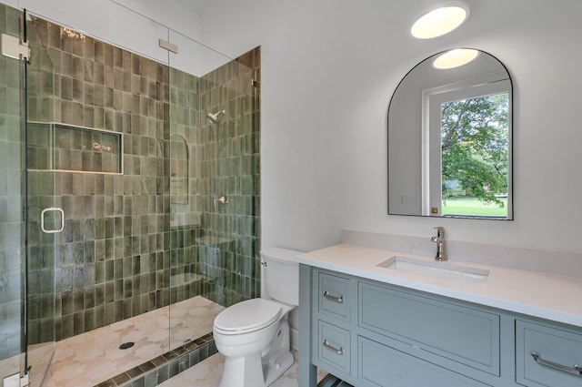 bathroom with a stall shower, vanity, and toilet