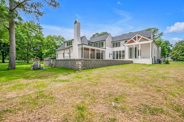 back of property with a lawn and a chimney