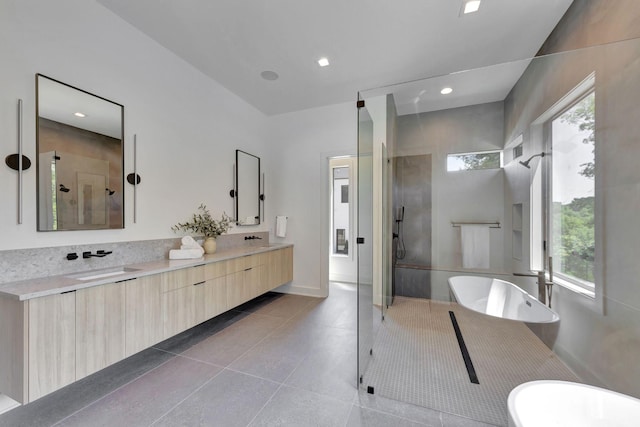 full bathroom featuring a stall shower, a soaking tub, a sink, and double vanity