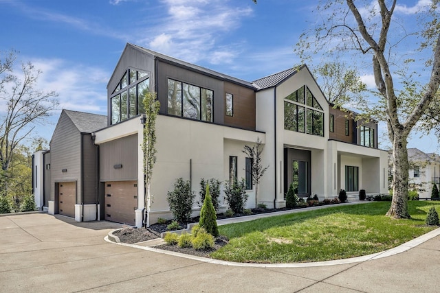 view of front of property featuring a garage, a standing seam roof, driveway, and a front lawn