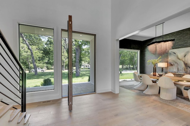 doorway featuring baseboards, stairs, visible vents, and wood finished floors