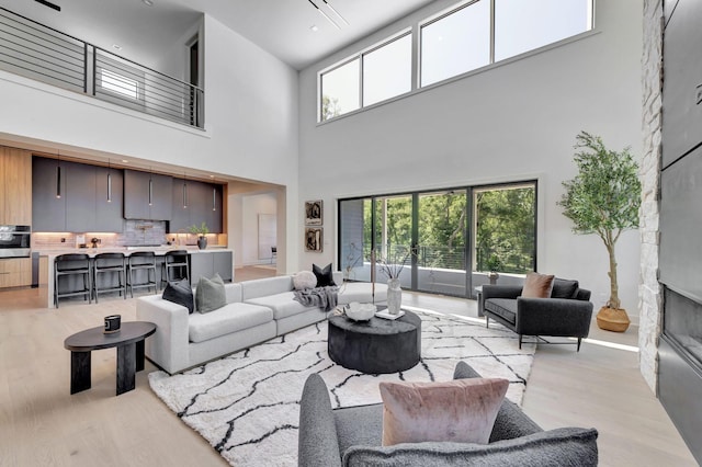 living room featuring light wood-style flooring and a glass covered fireplace