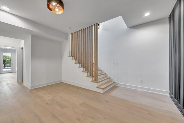 staircase featuring wood finished floors and baseboards