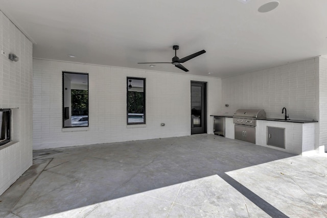 view of patio with area for grilling, an outdoor kitchen, a sink, and a ceiling fan