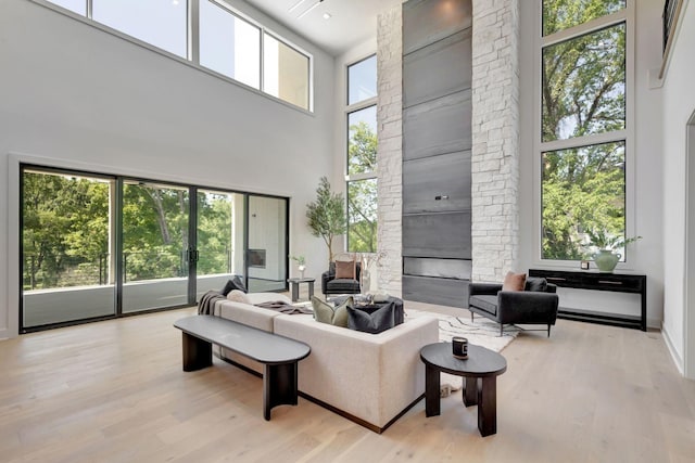 living room featuring light wood finished floors, a fireplace, and a wealth of natural light