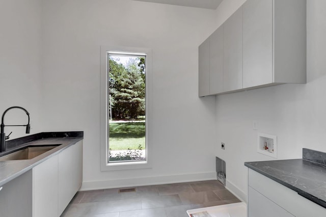 clothes washing area with plenty of natural light, washer hookup, cabinet space, and a sink