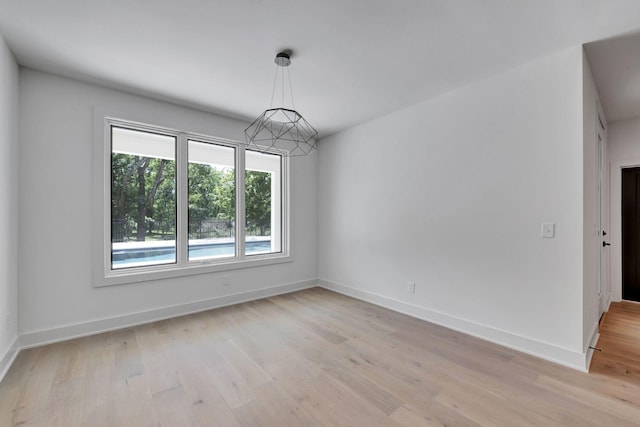 unfurnished room featuring light wood-type flooring and baseboards