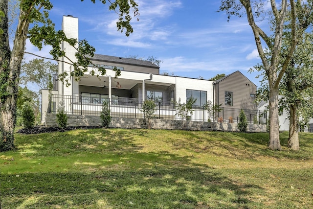 rear view of property featuring a yard and fence