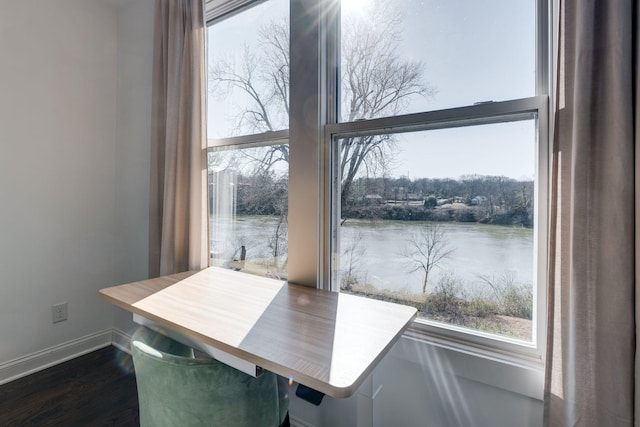 dining area with a water view, a healthy amount of sunlight, and dark wood finished floors