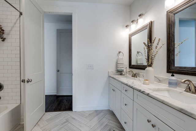 bathroom with double vanity, shower / bath combination, baseboards, and a sink