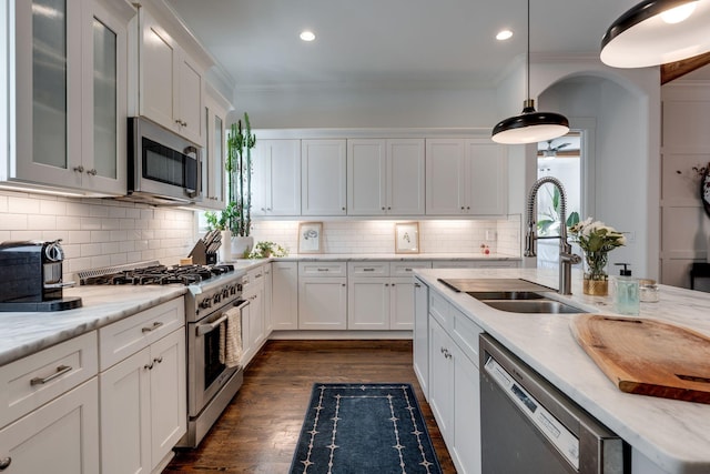 kitchen featuring white cabinetry, a sink, appliances with stainless steel finishes, and ornamental molding