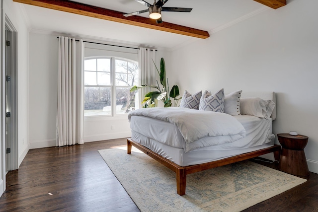 bedroom featuring baseboards, beam ceiling, wood finished floors, and ornamental molding