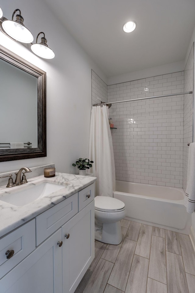 bathroom featuring shower / bathtub combination with curtain, vanity, toilet, and wood tiled floor