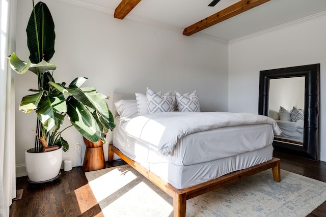 bedroom featuring beam ceiling, wood finished floors, and ornamental molding