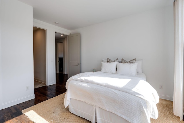 bedroom with wood finished floors and baseboards