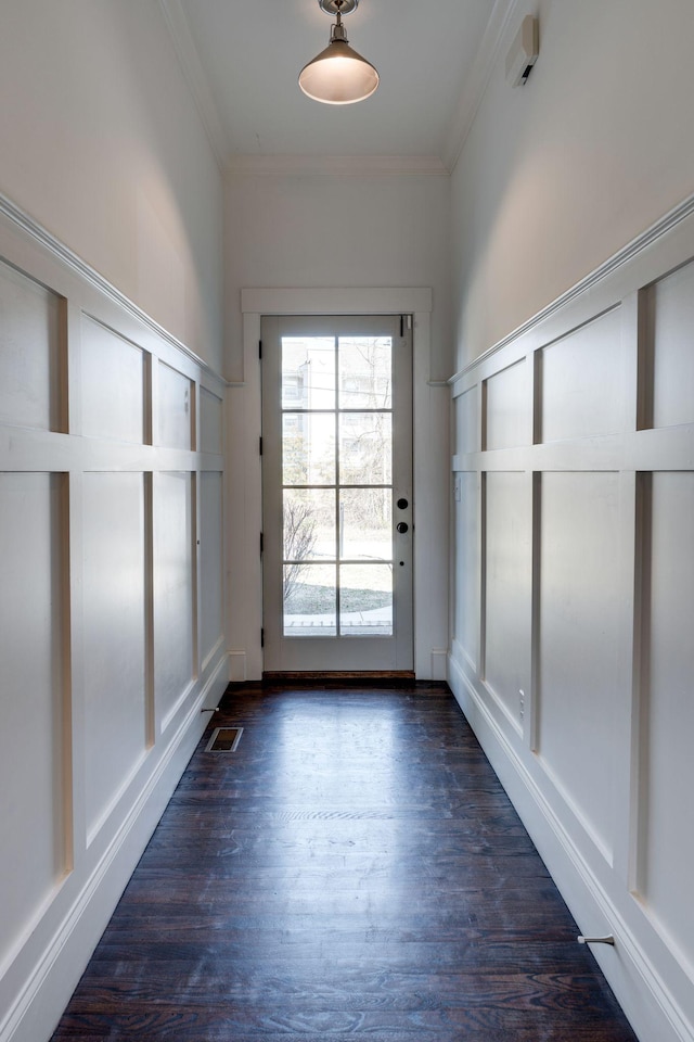 doorway featuring crown molding, dark wood-style floors, and visible vents