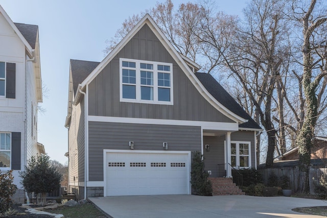 view of front of home with board and batten siding, concrete driveway, an attached garage, and roof with shingles