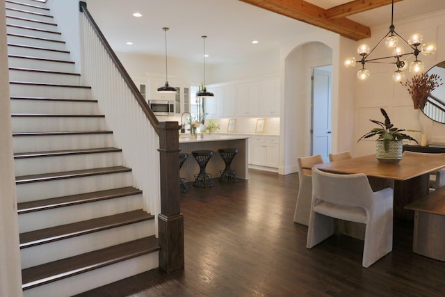 dining room with arched walkways, recessed lighting, stairs, and dark wood-style flooring