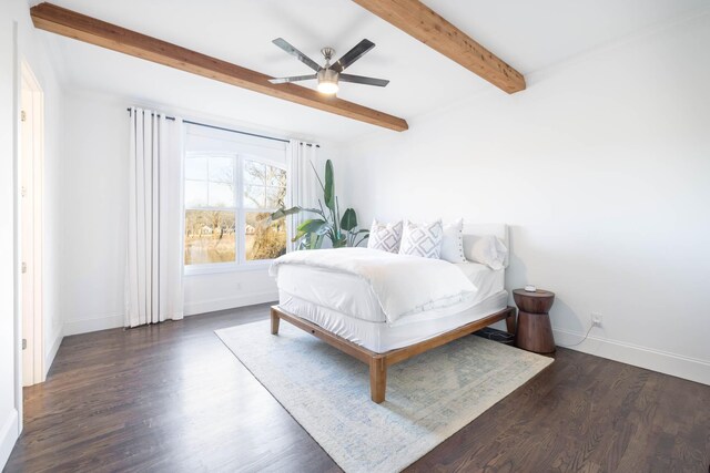 bedroom with ceiling fan, baseboards, beam ceiling, and wood finished floors