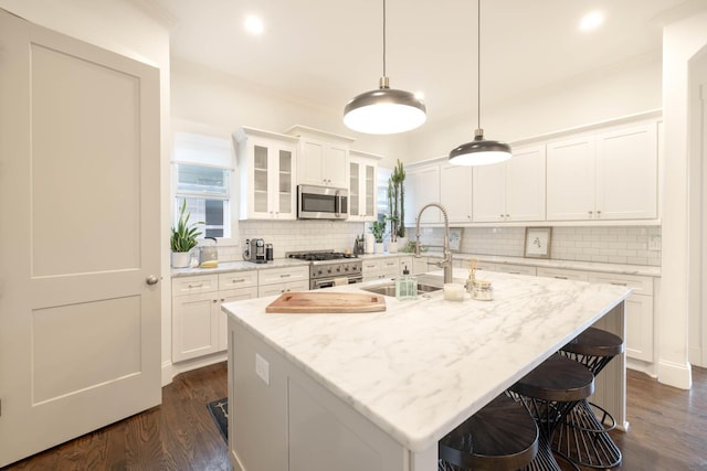 kitchen with stainless steel appliances, dark wood-style floors, and white cabinets