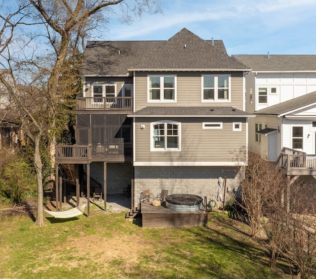 rear view of property with a shingled roof, stairs, a sunroom, a balcony, and a yard