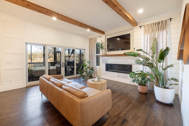 living area with wood finished floors, recessed lighting, a high end fireplace, beamed ceiling, and a decorative wall