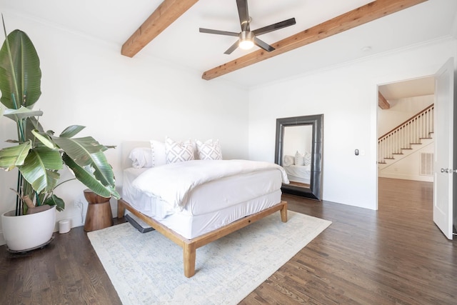 bedroom with a ceiling fan, wood finished floors, baseboards, visible vents, and beam ceiling