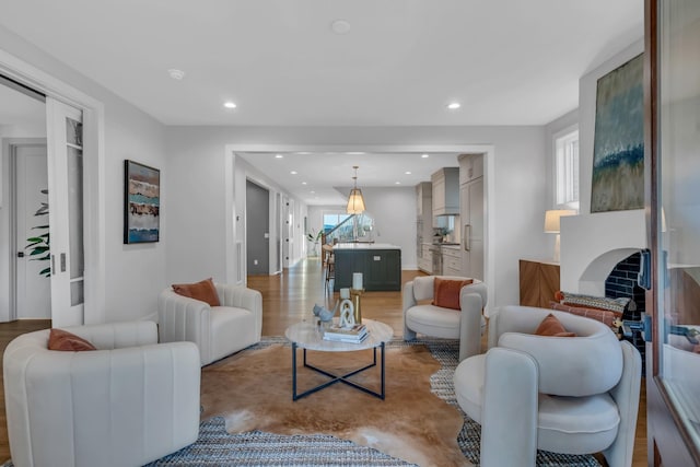 living room featuring light wood finished floors, a fireplace, and recessed lighting