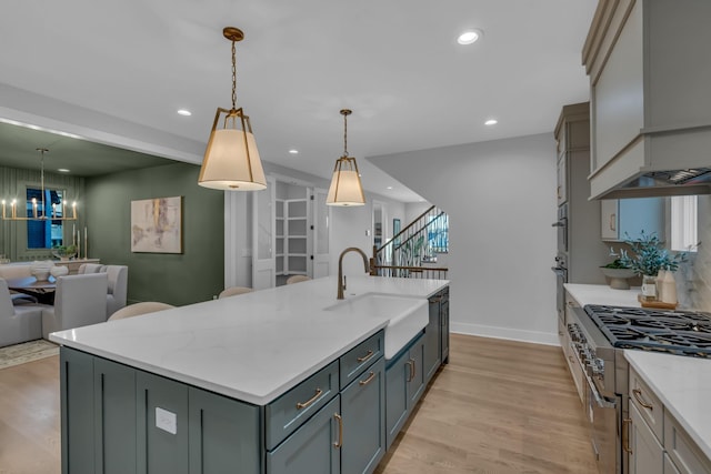 kitchen featuring recessed lighting, custom range hood, light wood-style flooring, open floor plan, and a sink