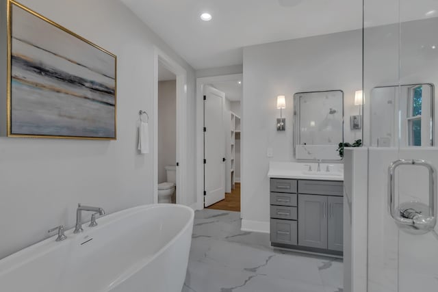 bathroom featuring a freestanding tub, recessed lighting, vanity, baseboards, and marble finish floor