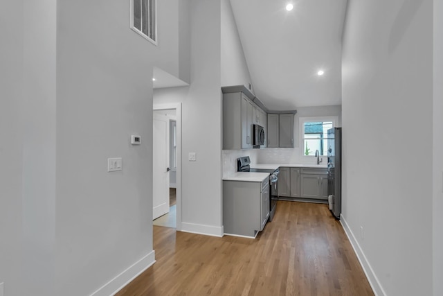 kitchen with visible vents, appliances with stainless steel finishes, gray cabinets, and baseboards