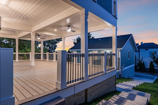 deck at dusk featuring ceiling fan