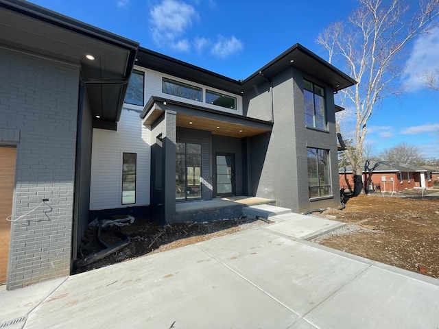 view of exterior entry featuring brick siding