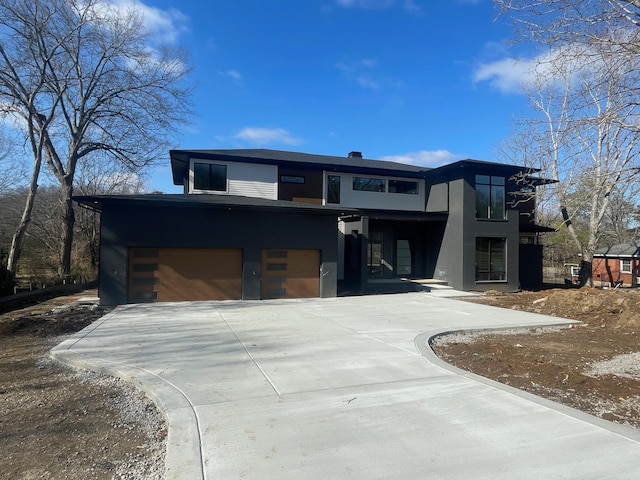 contemporary house with concrete driveway and an attached garage