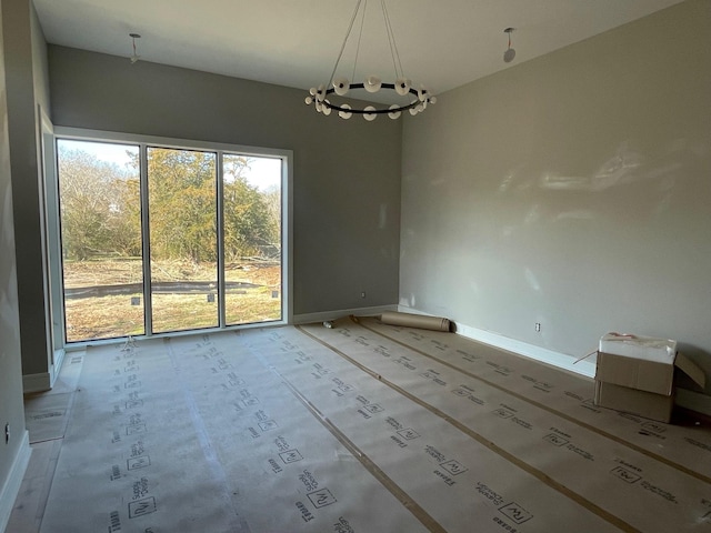 unfurnished dining area with a chandelier and baseboards