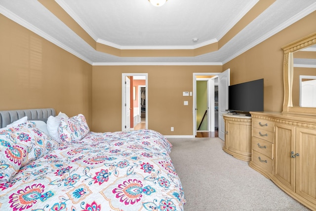 bedroom featuring crown molding, a tray ceiling, baseboards, and light colored carpet
