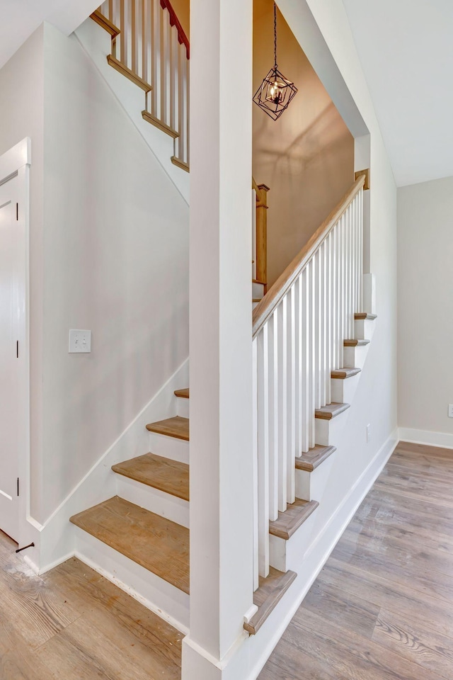 stairway featuring baseboards and wood finished floors