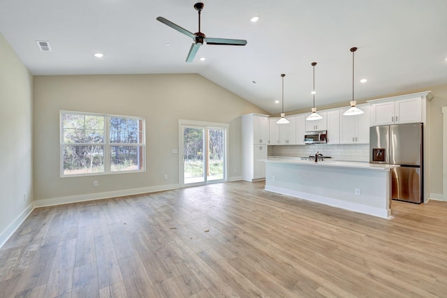 kitchen with appliances with stainless steel finishes, open floor plan, and visible vents