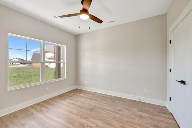 unfurnished room with light wood-style flooring, visible vents, ceiling fan, and baseboards